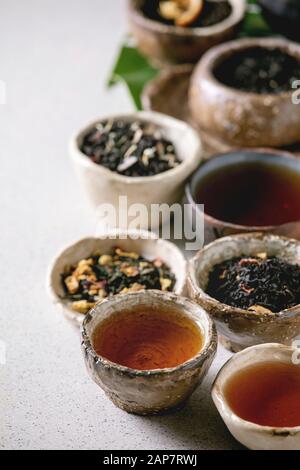 Variété de plats chauds et secs plateau vert et noir dans le style traditionnel et wabi sabi céramique argile tasses et bols d'artisanat sur gray background. Clos Banque D'Images