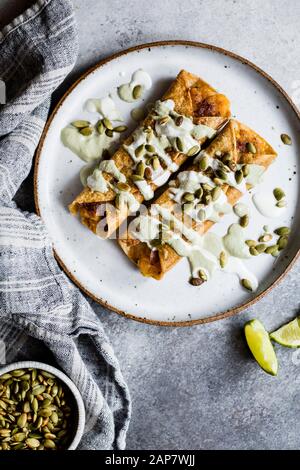 Taquitos de citrouille au fromage avec de la crème de jalapeno pepita rôtie Banque D'Images