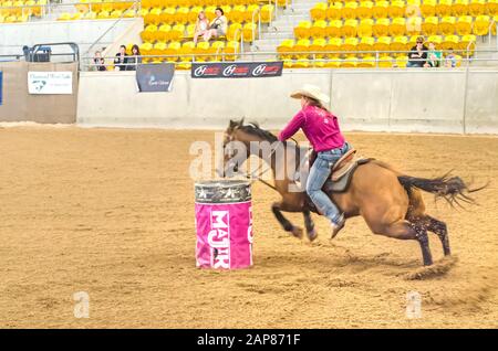 Cavalier féminin en compétition dans une course de tonneau. Banque D'Images