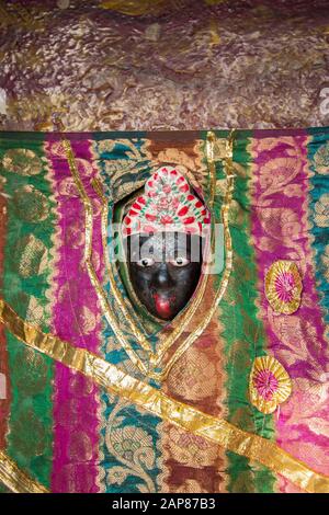 Une clôture d'une sculpture religieuse Sainte enveloppée dans du matériau sari en soie. À Varanasi, Benares, Uttar Pradesh, Inde. Banque D'Images