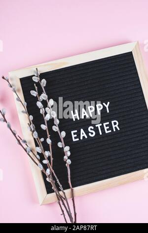Carte De Vœux De Pâques. Tableau de lettres noires avec texte Joyeuses Pâques et bouquet de fleurs de saules printanières. Plat, vue du dessus Banque D'Images
