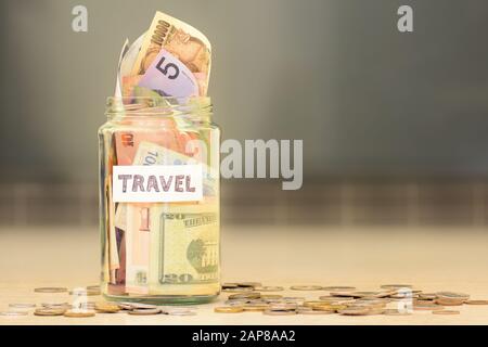 Les fonds de voyage sont pleins d'économies avec de l'argent de différents pays Banque D'Images