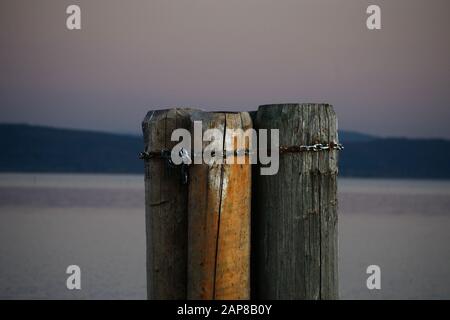 Jetée en bois pour amarrer des bateaux contre le lac Trasimeno en arrière-plan, pendant le coucher du soleil Banque D'Images