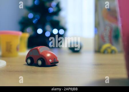 Mini voiture de course en peluche rouge sur fond intérieur de Noël Banque D'Images