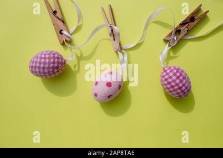 Joyeuses Pâques.carte de vœux avec œufs de pâques accrochés sur un manteau, fond rustique. Banque D'Images