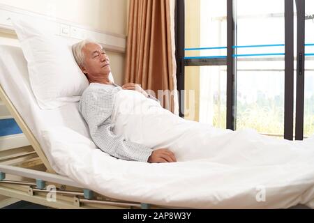patient asiatique âgé de sexe masculin allongé dans le lit dormant dans le service hospitalier ou dans un centre de vie assisté Banque D'Images