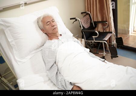 patient asiatique âgé de sexe masculin allongé dans le lit dormant dans le service hospitalier ou dans un centre de vie assisté Banque D'Images