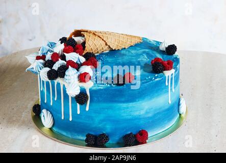 Gâteau bleu festif au chocolat et aux baies dans un pavillon à gaufres. Banque D'Images