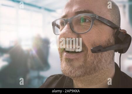 Homme dans un centre d'appels pour le bureau de service à la clientèle d'une entreprise. Espace de copie vide pour le texte de l'éditeur. Banque D'Images