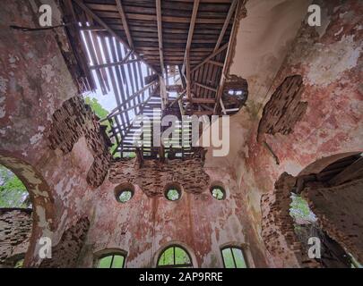 Vue de l'intérieur de l'ancienne église Saint Nicolas ruines en Estonie. Vert forêt couvrant la beauté de cet ancien bâtiment en ruine. Banque D'Images