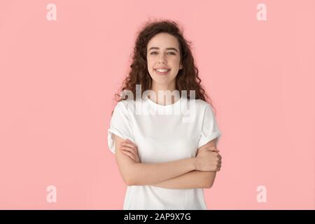 Heureuse fille millénaire confiante debout avec des mains croisées. Banque D'Images