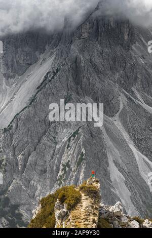 Mountaineer, femme debout sur une crête et regardant dans un cirque, nuages, dans les parois rocheuses arrière de Cimon di Croda Liscia, Auronzo di Cadore Banque D'Images