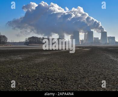 21 janvier 2020, Brandebourg, Peitz: La vapeur d'eau s'élève des tours de refroidissement de la centrale électrique au lignite Jänschwalde Lauritz Energie Bergbau AG (LEAG), alors qu'en premier plan on peut voir le fond ouvert déchiré d'un étang de poissons drainé. Le calendrier du gouvernement fédéral pour l'élimination progressive du lignite, avec les délais pour les centrales Jänschwalde et Schwarze Puppe (Spree-Neisse), a été reçu différemment dans la région de Brandenburg Lausitz. Selon les plans, la centrale électrique au lignite Jänschwalde doit être fermée entre 2025 et 2028. Deux blocs ont déjà été Banque D'Images