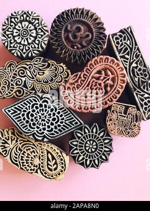 Timbres en bois Creative Flat Lay kalamkari sur fond couleur pastel. Fond plat géométrique en papier couleur pastel rose avec kalamkari sta indien Banque D'Images