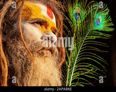 Portrait d'un Sadhu, Saint-Homme, consacré au Dieu Rama, une plume de paon derrière lui, au temple de Pashupatinath Banque D'Images