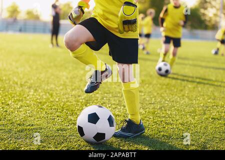 Joueurs de football sur le terrain d'entraînement sur le camp de football. Les enfants pratiquent le football le jour d'été. Les enfants participent à un camp sportif pour des jeux de football pour jeunes de talent Banque D'Images