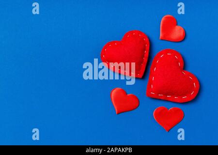 Vue de dessus de la composition des coeurs rouges sur fond coloré. Concept de relation romantique. La journée de Valentaine. Banque D'Images