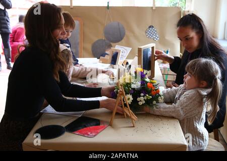 La duchesse de Cambridge reçoit un bouquet de fleurs de l'Eron, quatre ans, lors d'une visite au Centre pour enfants Ely & Caerau à Cardiff. Banque D'Images