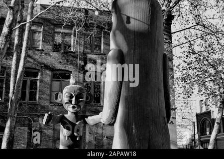 Art américain natif sous forme de totem Poles en bois sur Pioneer Square, Seattle, État de Washington, États-Unis. Tourné en noir et blanc. Banque D'Images