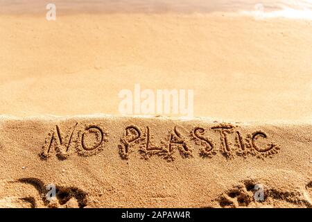 Pas de texte en plastique écrit à la main sur fond de plage de sable. Problème de pollution des océans Banque D'Images