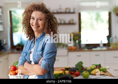 Portrait d'une femme souriante dans sa cuisine Banque D'Images