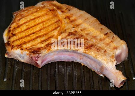 Côtes grillées savoureuses avec friture au romarin dans une poêle à frire. Vues de dessus Banque D'Images