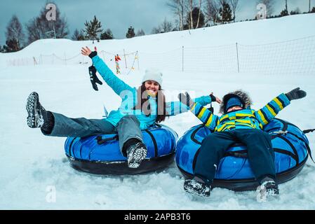 Jeune femme avec enfant sur snow tubes Banque D'Images