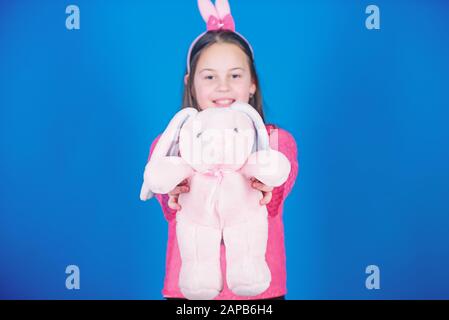 Enfant dans les oreilles de lapin de lapin. Joyeuses pâques. Fête du printemps. Chasse aux œufs. Vacances en famille. Petite fille avec jouet lièvre. Jeune et insouciant. Famille de lapin avec oreilles de lapin. Lapin le jour de pâques. Drôle de lapin. Banque D'Images