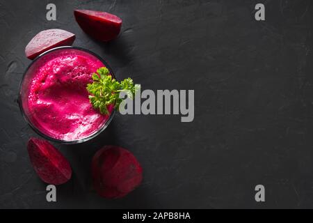 Verre de jus de betteraves rouges garnir persil sur le tableau noir. Vue d'en haut. Close up. Banque D'Images