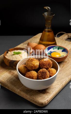 Croquettes maison avec leurs ingrédients, fond rustique sombre avec espace pour le copier, pain rayé, oeuf, huile d'olive Banque D'Images