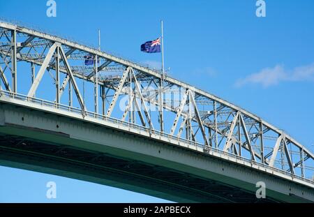 Drapeau volant en demi-mât sur le pont du port au-dessus du port de Waitemata, Auckland, Nouvelle-Zélande. Banque D'Images