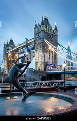 David Wynne's Girl avec une statue de dauphin et une fontaine sous le Tower Bridge, Londres, Angleterre, Royaume-Uni Banque D'Images