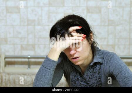 Une jeune femme ressent un mal de tête grave, touchant son front avec sa main. Fille souffrant de migraine, éprouvant une attaque de panique soudaine ou anxiet Banque D'Images