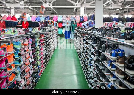 Chelyabinsk, Russie - septembre 2019: De belles sneakers sportives lumineuses se tiennent sur des rayonnages dans un magasin de vêtements et de chaussures. En arrière-plan sont des échantillons de Banque D'Images