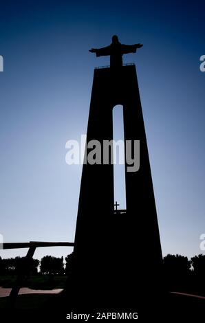Silhoutte du Sanctuaire National du Christ le Roi à Almada face à Lisbonne. Vue frontale de l'avant en dessous contre un ciel bleu clair. Portugal. Banque D'Images