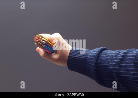 couleurs avec le point vif, groupe de couleurs unis dans la main d'une personne adulte; couleurs assorties dans différents crayons Banque D'Images