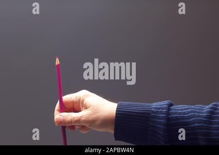 couleurs avec le point vif, groupe de couleurs unis dans la main d'une personne adulte; couleurs assorties dans différents crayons Banque D'Images