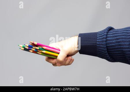 couleurs avec le point vif, groupe de couleurs unis dans la main d'une personne adulte; couleurs assorties dans différents crayons Banque D'Images