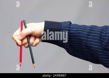 couleurs avec le point vif, groupe de couleurs unis dans la main d'une personne adulte; couleurs assorties dans différents crayons Banque D'Images