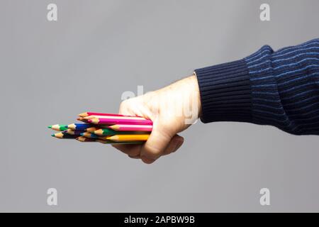 couleurs avec le point vif, groupe de couleurs unis dans la main d'une personne adulte; couleurs assorties dans différents crayons Banque D'Images