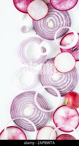 Vue en haut vers le bas d'un arrangement abstrait de chevauchement des tranches d'oignon rouge avec le daikon et les radis. Banque D'Images