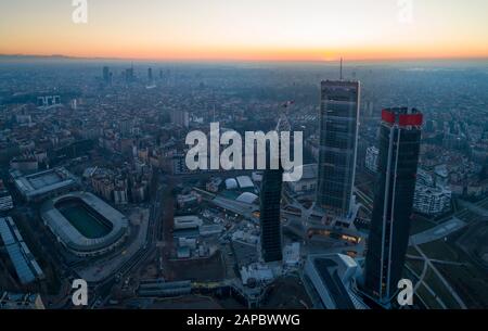 Ville de Milan au lever du soleil, vue aérienne. Les 3 nouveaux gratte-ciel (appelés le droit, le courbé et le crocheté) du quartier de Citylife à l'aube. Banque D'Images