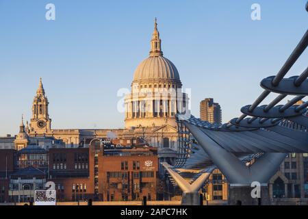 Le dôme de la cathédrale Saint-Paul avec la brique brune City de Londres école privée de garçons illuminée par la lumière du soleil et le pont piéton Millennium Banque D'Images