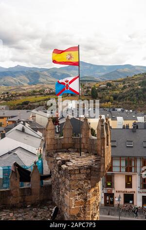 Les drapeaux de la région de Bierzo et d'Espagne survolent Ponferrada, Castille et Leon. Une tourelle du château des Templiers, des montagnes et des vignobles au loin. Banque D'Images