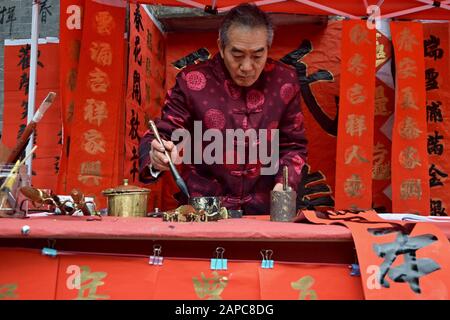 Foshan, CHINE - VERS JANVIER 2020: Un homme écrivant des couples de bénédiction pendant le Festival de printemps. Une traduction des couplets est Heureuse et propérie année Banque D'Images