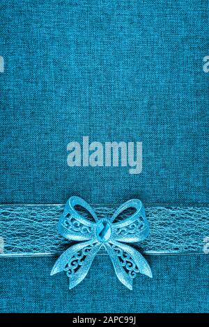 Élégant noeud brillant bleu brillant sur ruban bleu et sur toile bleu. Fond vertical de carte de vœux avec grand espace de copie et fond décoré Banque D'Images