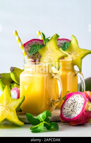 Un gros plan vertical de deux smoothies aux fruits exotiques tropicaux prêts à boire. Banque D'Images