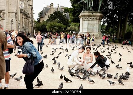 Photo de rue d'une séance de noces avec pigeons, statue de Charlemagne et ses Leudes à Cathédrale notre-Dame de Paris. Banque D'Images