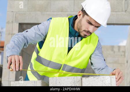 une brique mesure un mur Banque D'Images