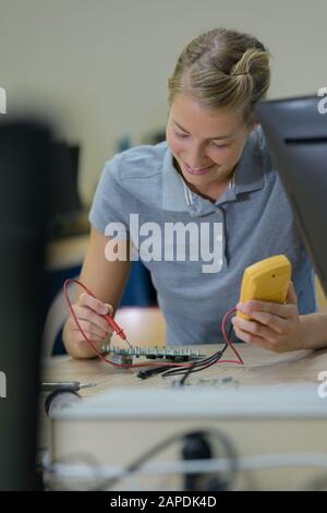 l'assistant de laboratoire femelle répare le module pcb pour la robotique cnc Banque D'Images